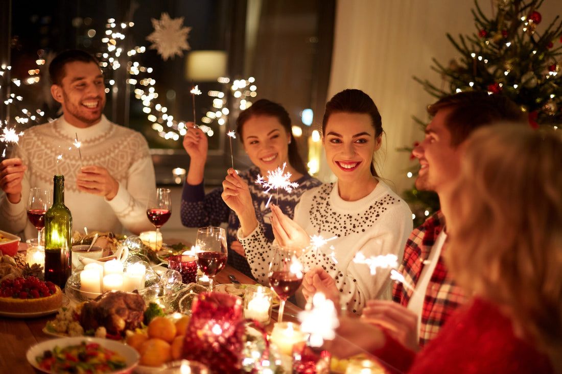 Young people sitting down to a holiday meal with sparklers